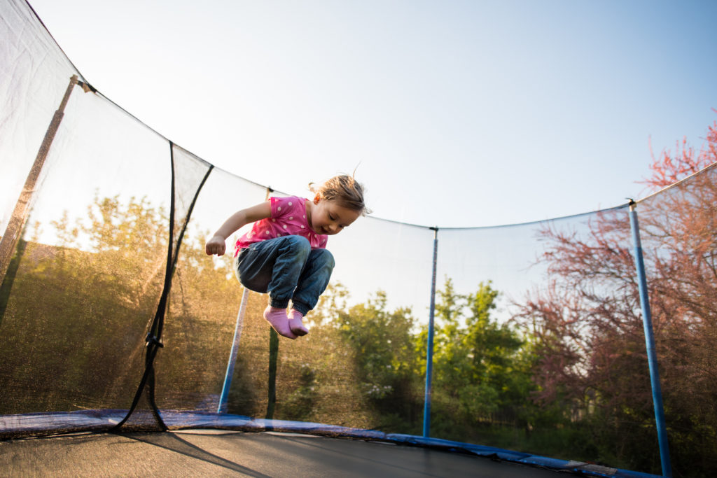 little girl jumping on trampoline little girl jumping on trampoline in backyard