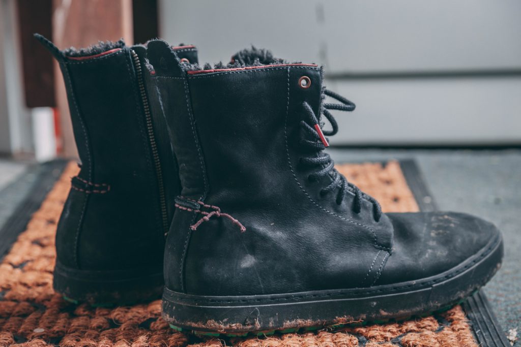pair-of-black-lace-up-boots-on-area-rug-1467574