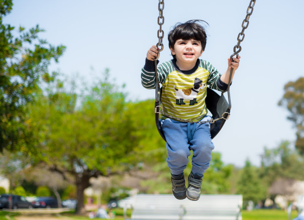 young kid on a swing set